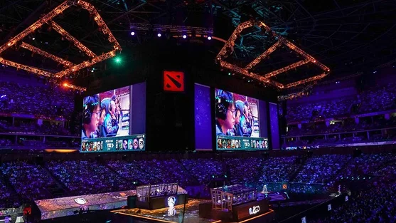 grote esports-arena vol met toeschouwers die naar een Dota 2-wedstrijd op grote schermen kijken